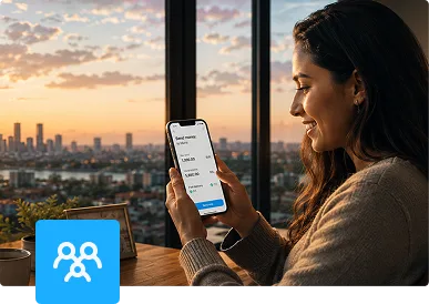Mujer enviando dinero desde una app de pagos en su móvil junto a una ventana con la ciudad al atardecer